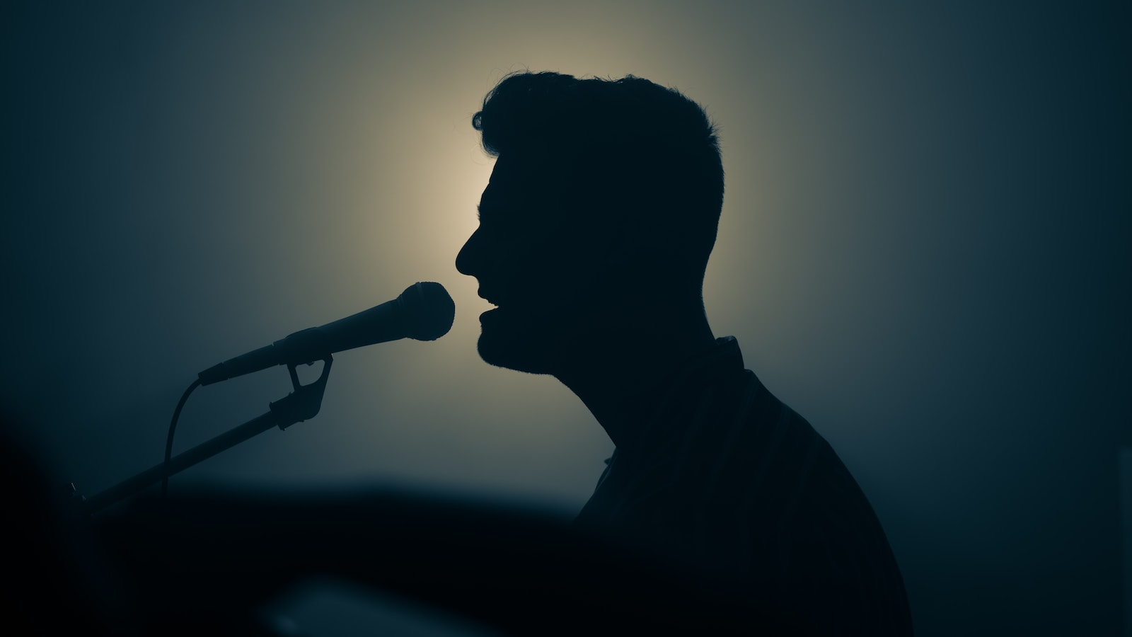 a silhouette of a man singing. music minsitry. worship